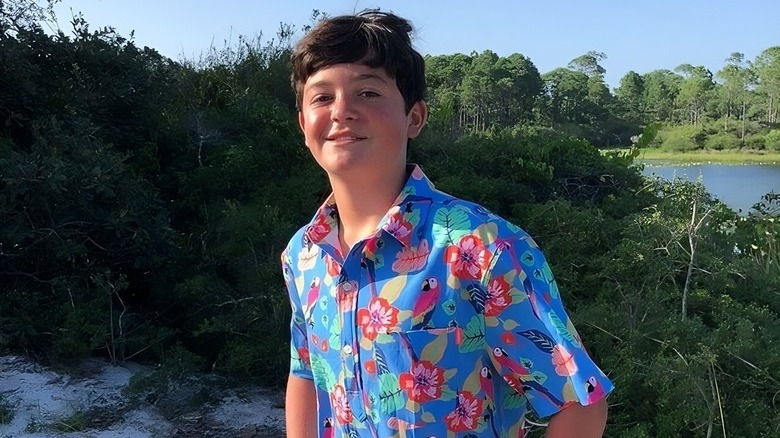 Jack Deen smiles while posing in a multicolored shirt