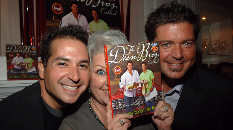 Bobby, Paula, and Jamie Deen pose with a copy of the brothers' cookbook