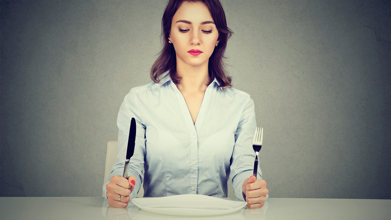 woman at table with fork and knife