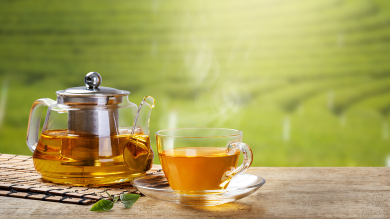 Teacup next to a tea kettle