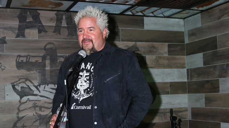 Guy fieri standing wearing black jacket and T-shirt