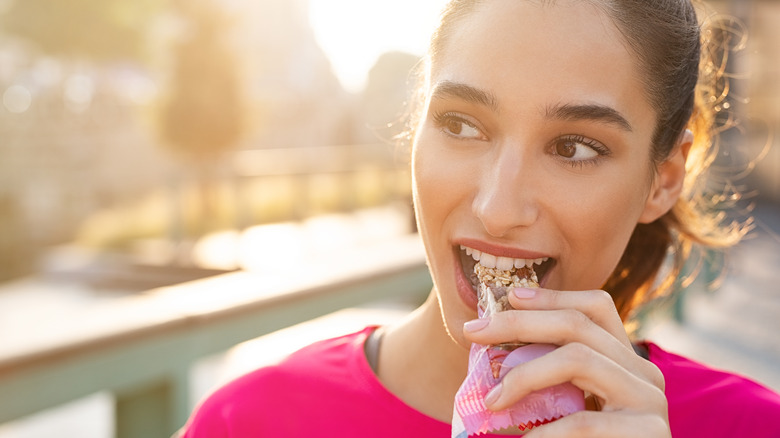 woman eating protein bar