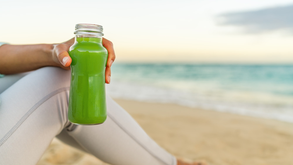 Woman with bottle of green juice