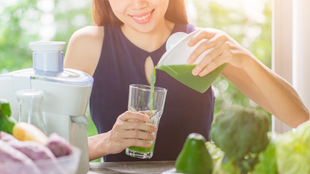 Woman pouring green juice