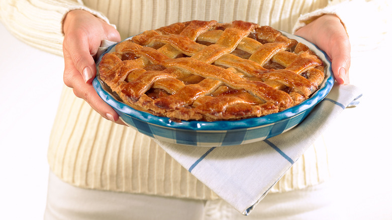 Woman holding homemade apple pie