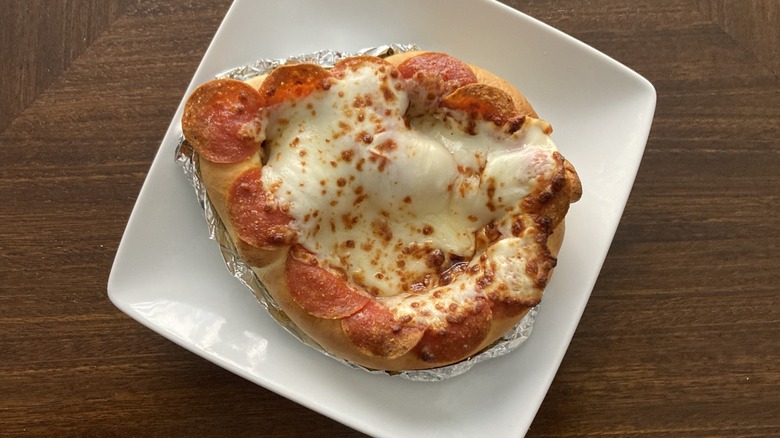 A plate holds a pizza pretzel.