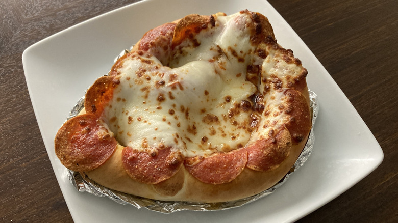 A pizza pretzel from Sam's Club rests on a white plate.