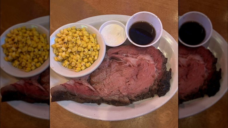 Prime rib on plate with corn and sauces