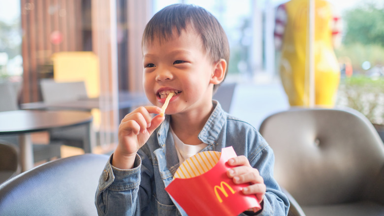 Young boy eating McDonald's fries