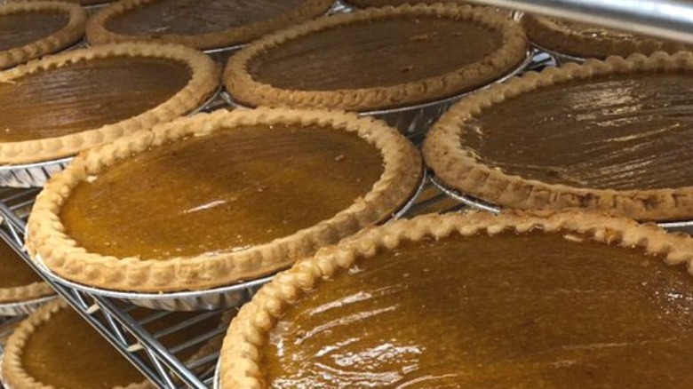 Dozens of pumpkin pies on racks