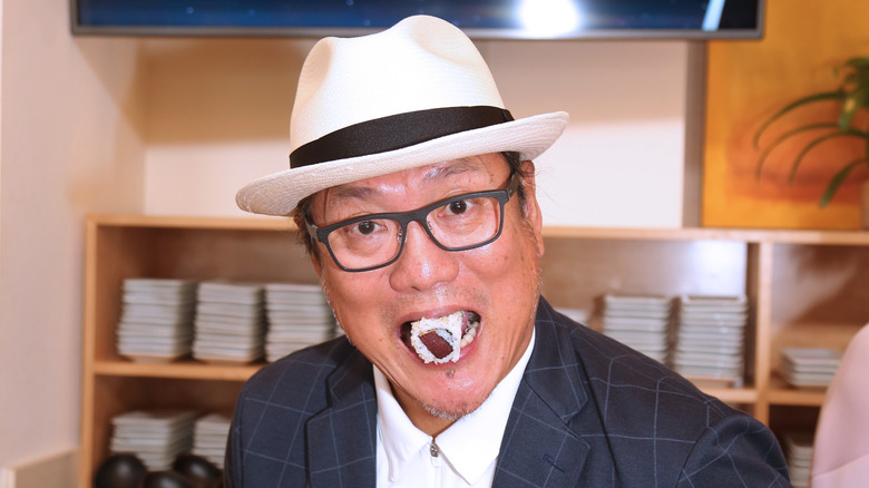 Iron Chef Morimoto with sushi in his mouth