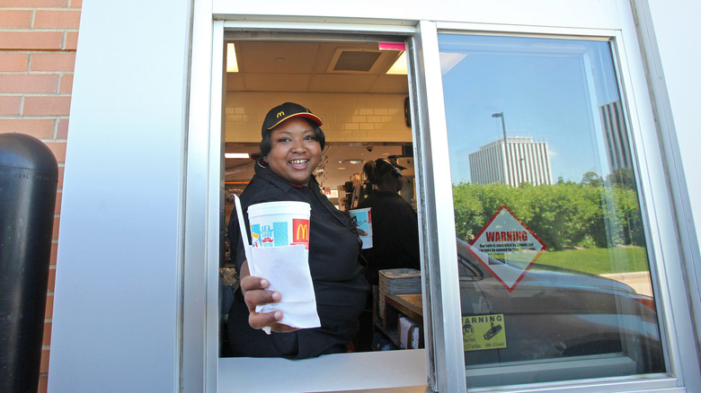 mcdonald's drive-thru employee handing drink