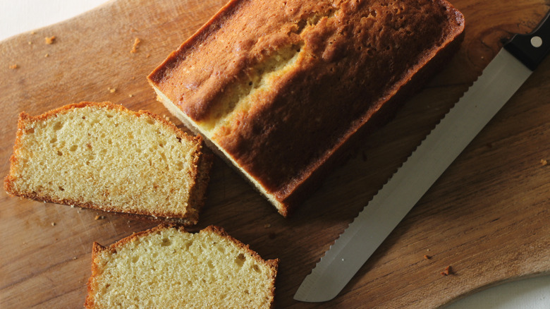 Pound cake with knife on cutting board