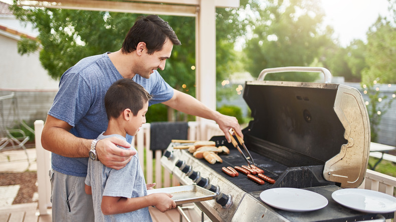 Family cooking on propane grill