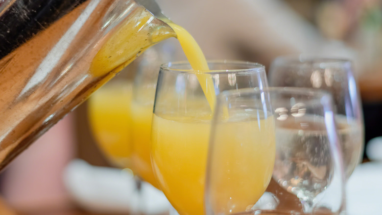 pouring oj into champagne