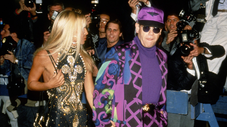 Elton John and Donatella Versace walking past paparazzi