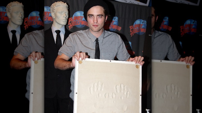 Robert Pattison holding donated memorabilia