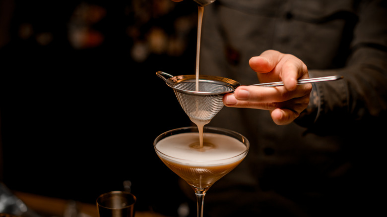 Bartender pouring espresso martini cocktail