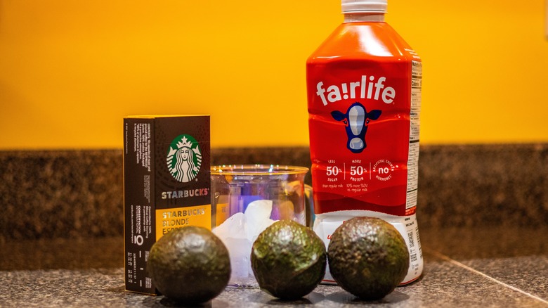 Three avocados, glass of ice, Starbucks espresso pods and Fairlife milk