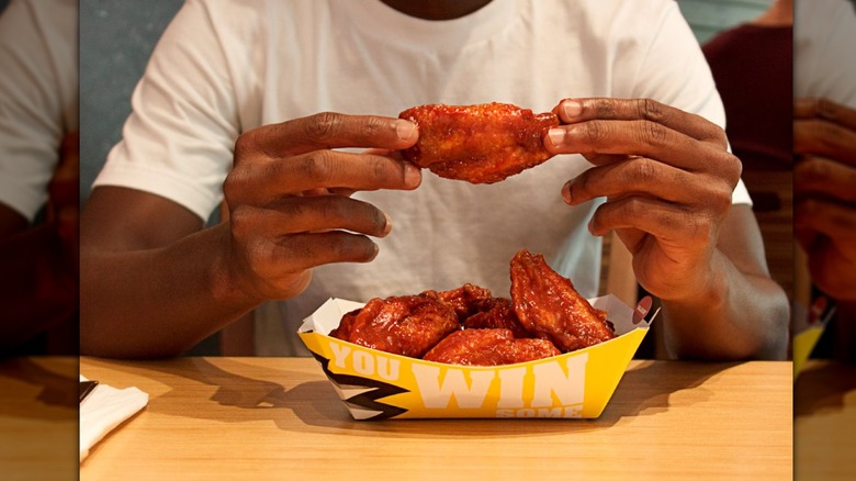 person holding hot wings