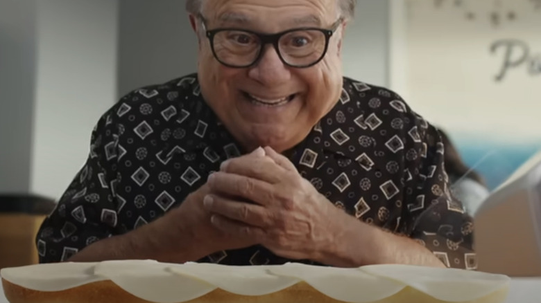 Danny DeVito staring at a big sandwich