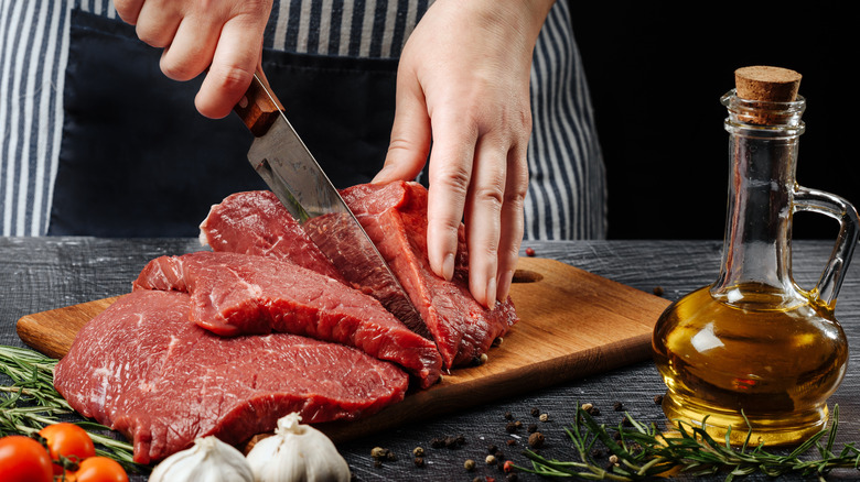 chef cutting raw beef