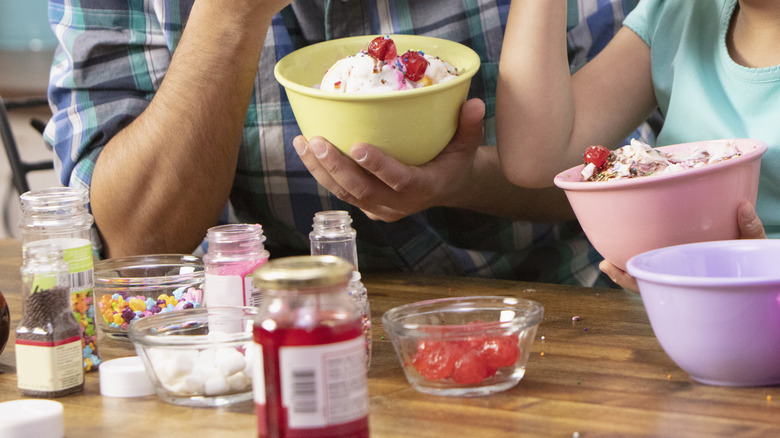 Parent and child enjoying homemade sundaes