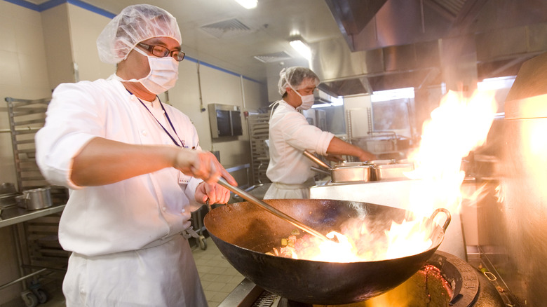 chef cooking with a wok