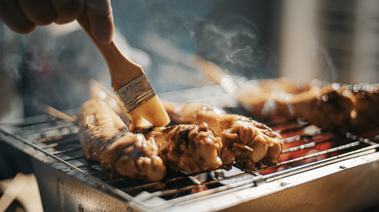 Brushing sauce onto chicken skewers