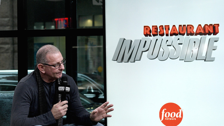 Robert Irvine next to "Restaurant: Impossible" logo