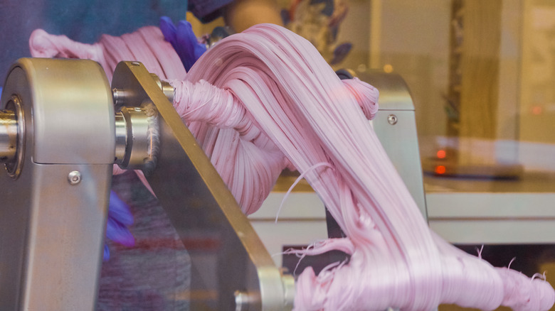 Machine churning out pink salt water taffy