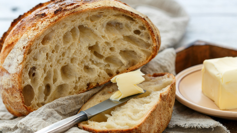 Butter being spread on fresh bread
