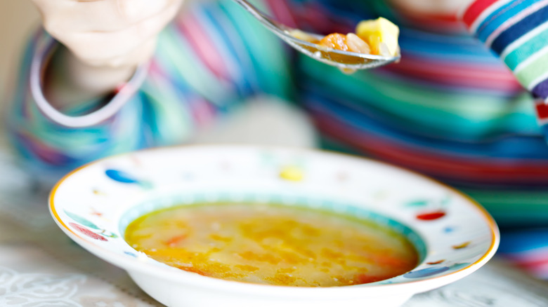Child eating vegetable soup