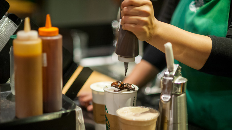 Starbucks barista drizzling syrup