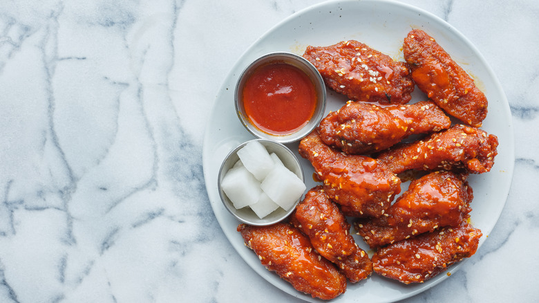 Korean fried chicken wings with hot sauce and pickles