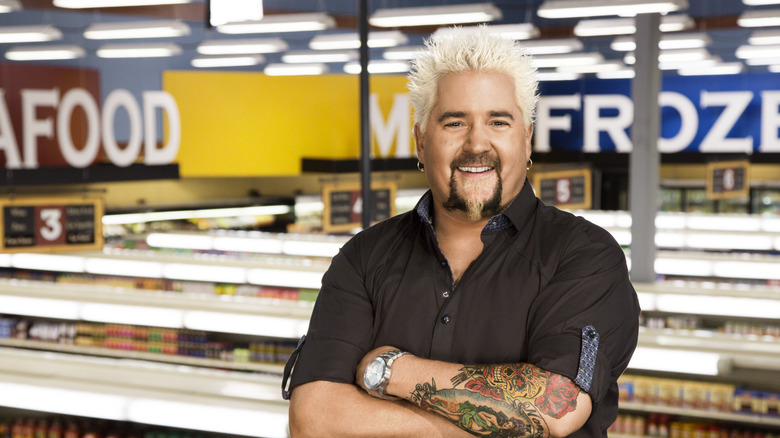 Guy Fieri standing with arms crossed