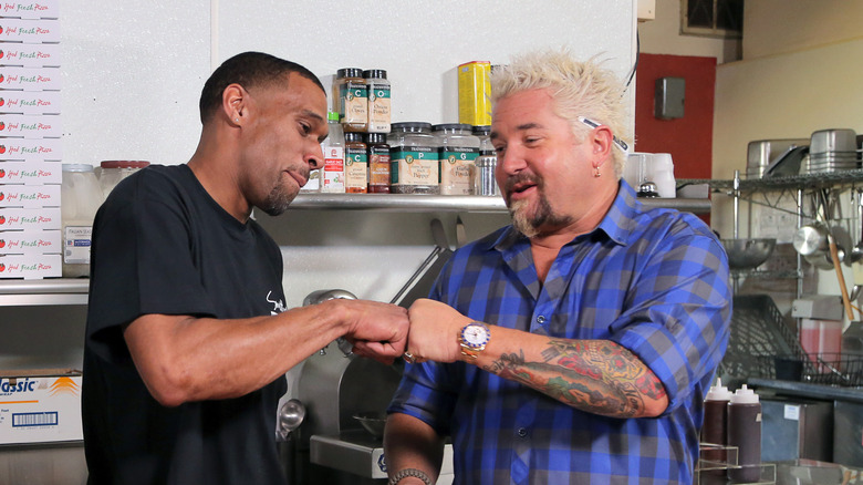 Chef on left fist-bumping Guy Fieri, on right