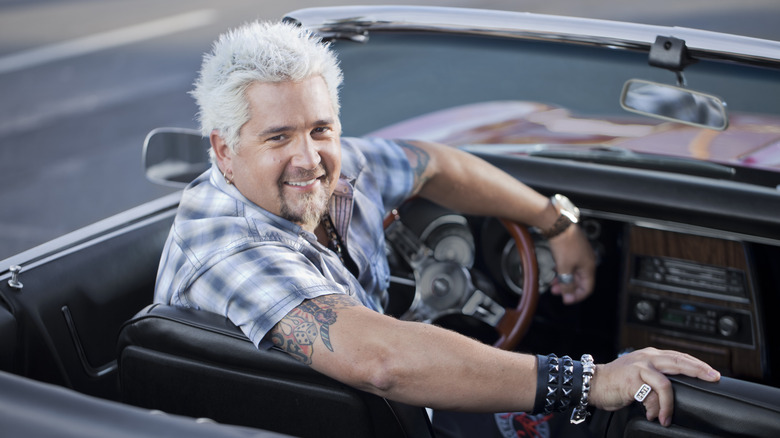 Guy Fieri in car, turning to look towards camera