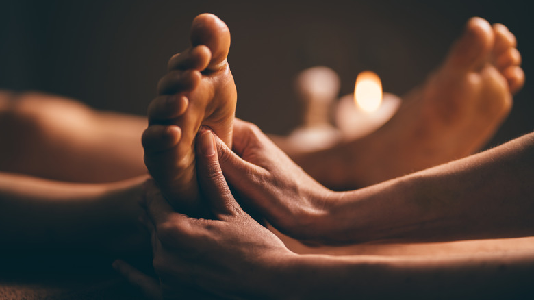 Massage therapist rubbing client's feet