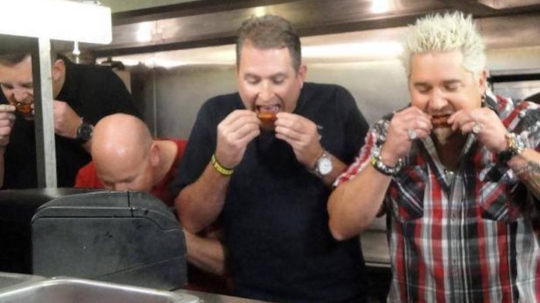 Guy Fieri and crew eating chicken wings