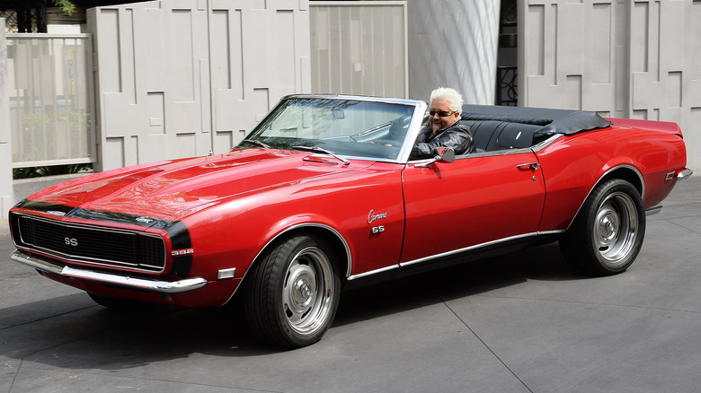 Guy Fieri smiles in red Camaro