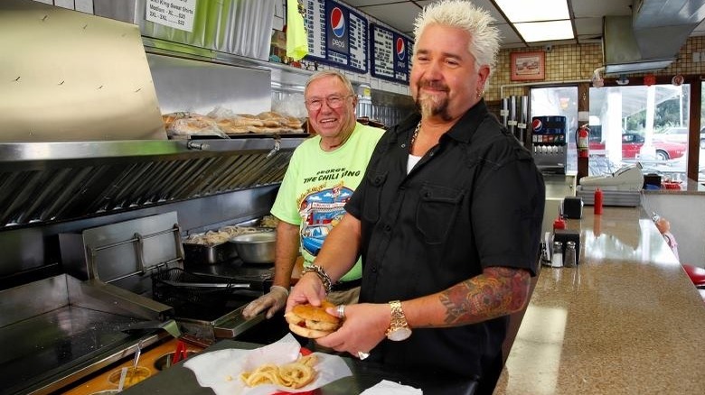 Guy Fieri with a chef holding a burger