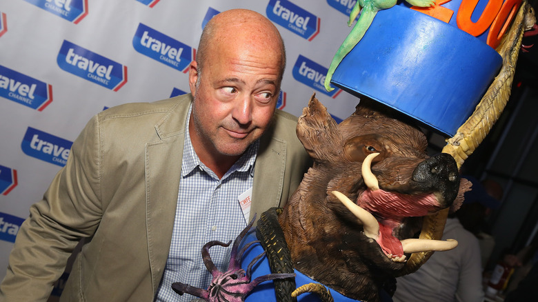 Andrew Zimmern looking at plastic animals
