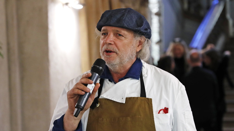 Francis Mallmann holds a microphone