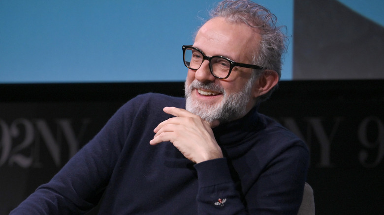 Massimo Bottura smiling in a chair