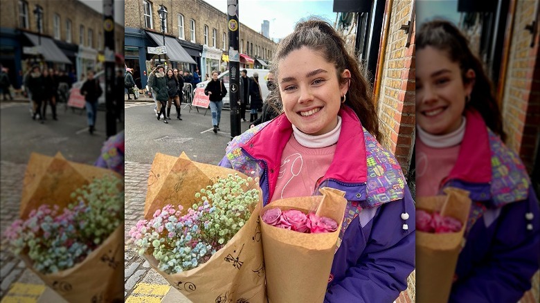 Freya on sidewalk holding flower bouquets