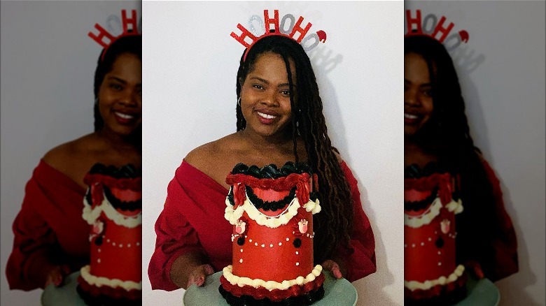 Rochica posing for a Christmas photo with a cake