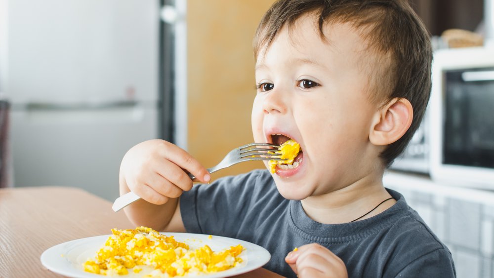 Young child eating scrambled eggs