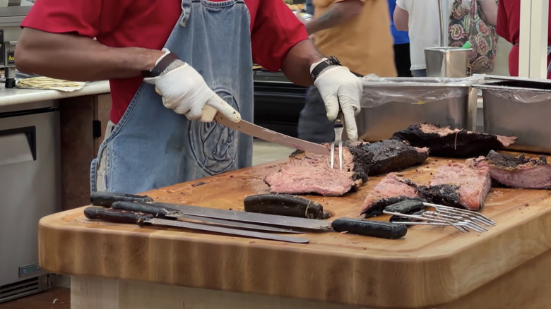 Person carving barbecue meat