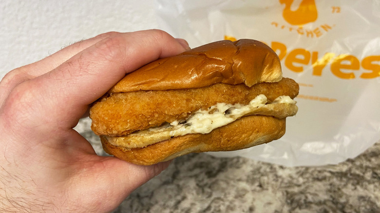 Hand Holding Fish Sandwich